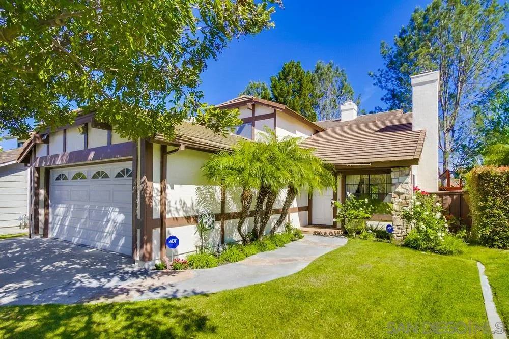 a view of a house with a yard and potted plants