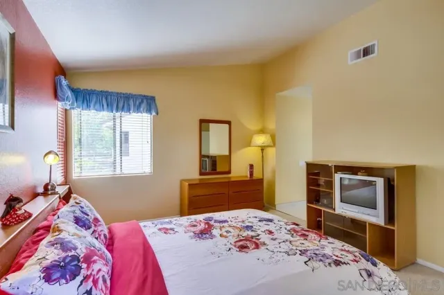 a bedroom with a bed and a dresser in it