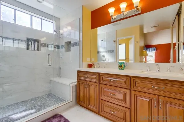 a bathroom with a granite countertop sink a mirror and a bathtub