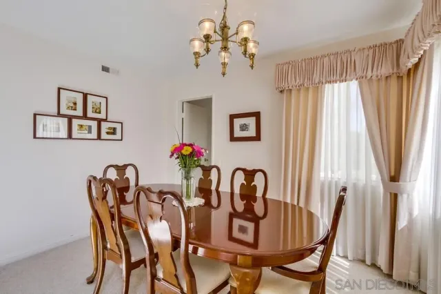 a view of a dining room with furniture and a chandelier