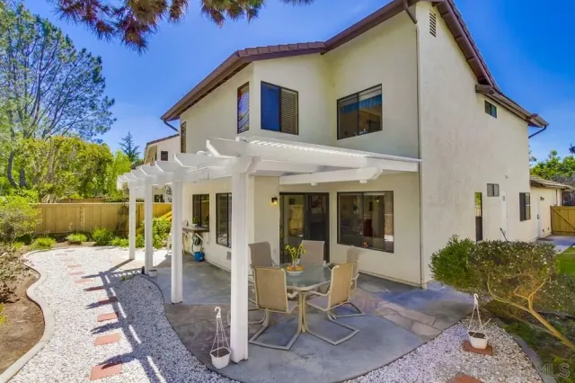 a view of a house with backyard and sitting area