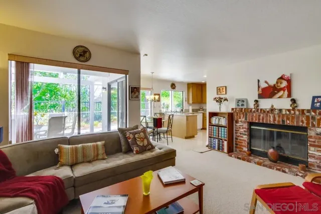a living room with furniture a flat screen tv and a floor to ceiling window