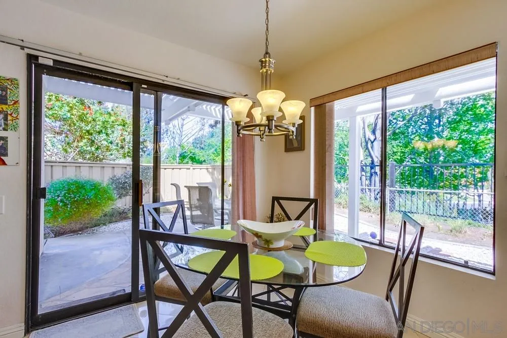 13354 Benchley Road San Diego, CA 92130 - Photo 7 of 24 a dining room with furniture a chandelier and garden view