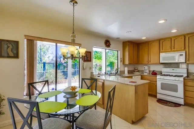 a kitchen with a dining table chairs and white cabinets