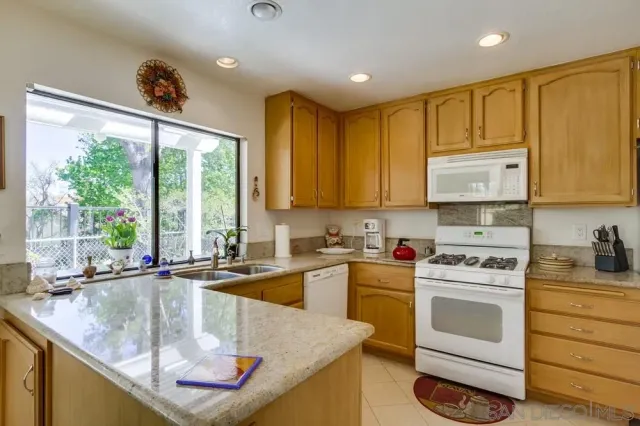 a kitchen with stainless steel appliances granite countertop a sink a stove and cabinets