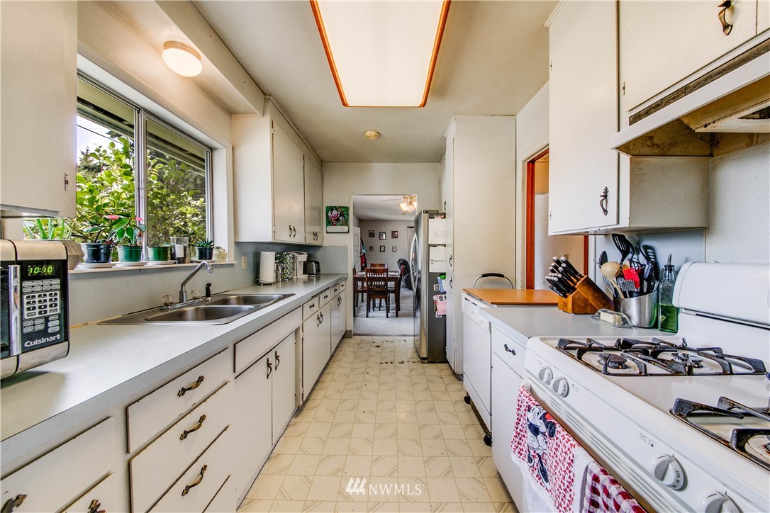 902 South Mullen Street Tacoma, WA 98405 - Photo 14 of 30 a large kitchen with stainless steel appliances granite countertop a stove a sink dishwasher and cabinets with wooden floor