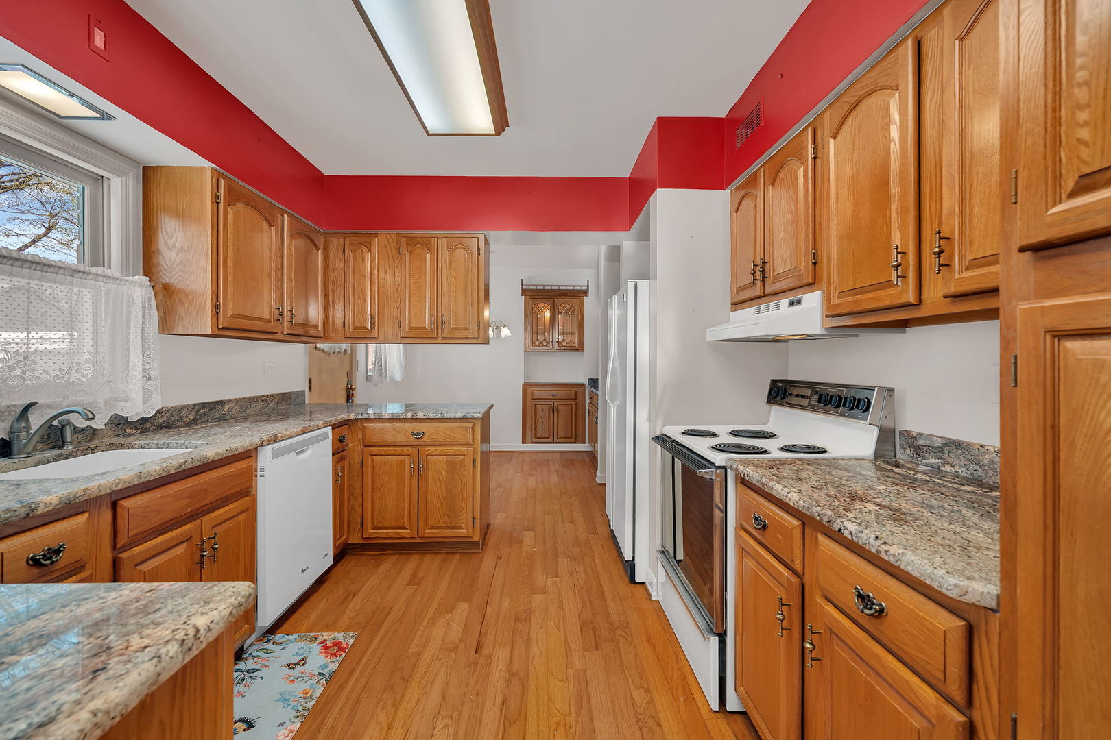 409 West Jefferson Street Morris, IL 60450 - Photo 4 of 44 a kitchen with granite countertop a stove a sink dishwasher and cabinets with wooden floor