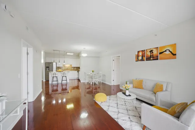 a living room with furniture and a view of kitchen