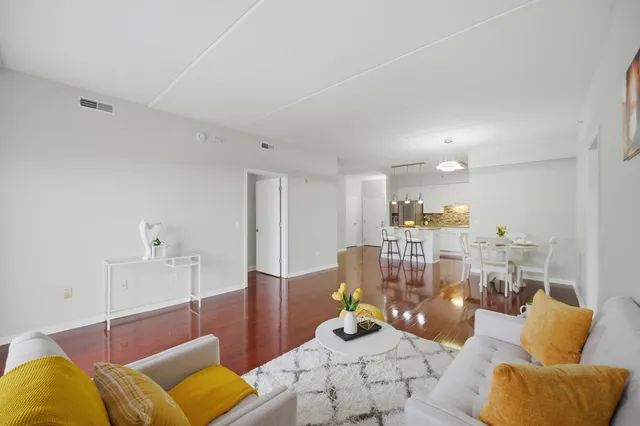 a living room with furniture kitchen view and a chandelier