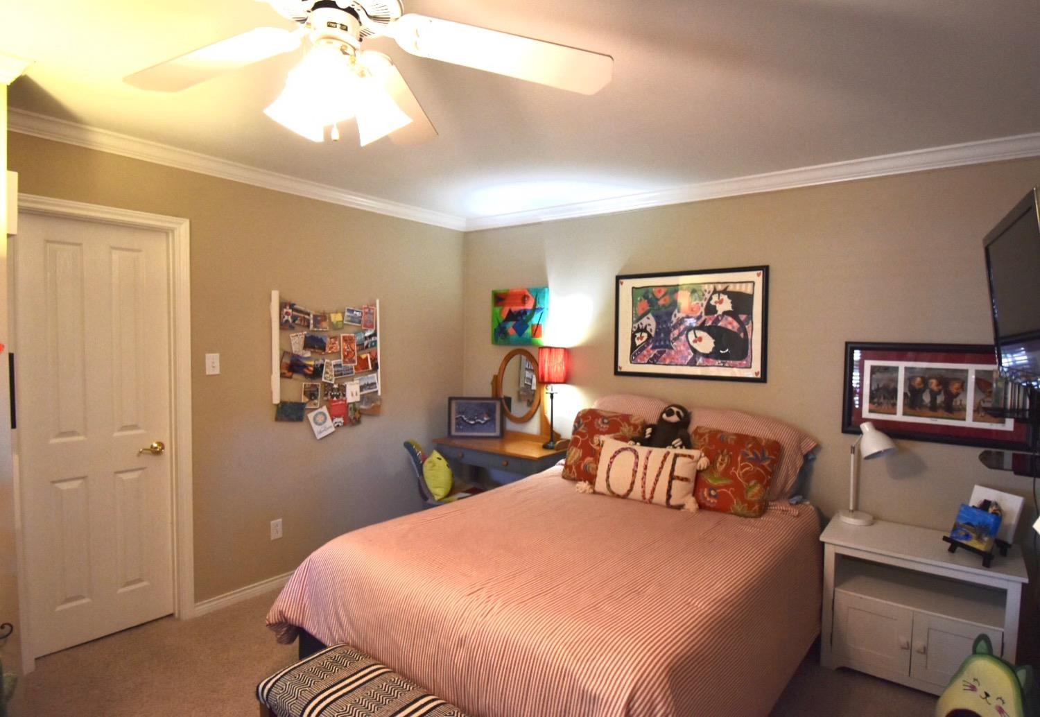8201 Durham Avenue Lubbock, TX 79424 - Photo 22 of 33 a bedroom with a bed and a chandelier