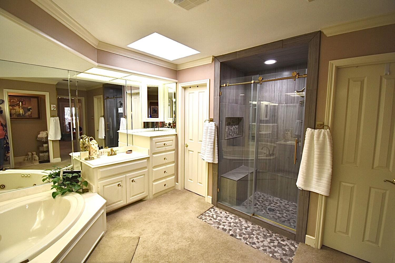 8201 Durham Avenue Lubbock, TX 79424 - Photo 29 of 33 a large bathroom with a glass door shower a sink and a mirror