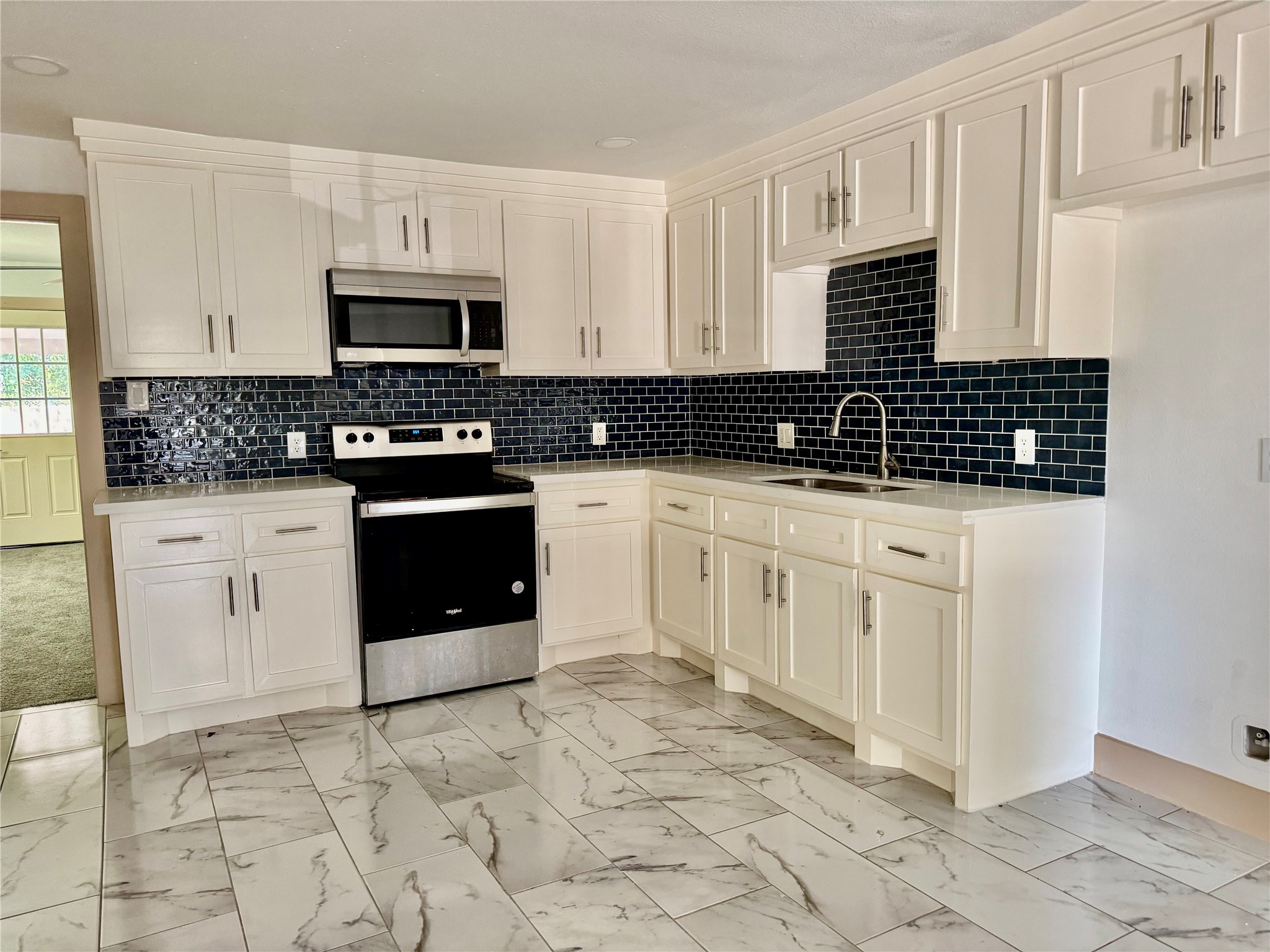 a kitchen with granite countertop white cabinets and appliances