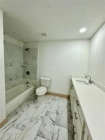 a bathroom with a sink a toilet and bathtub
