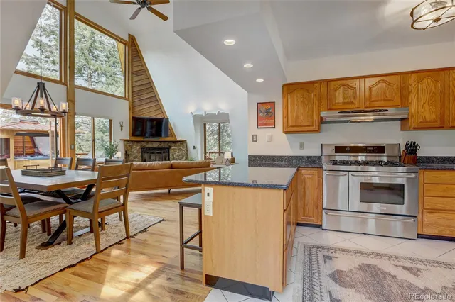 a kitchen with stainless steel appliances kitchen island granite countertop a stove a sink and a microwave