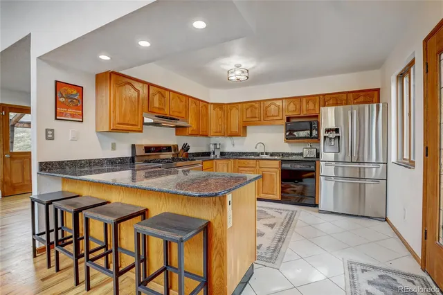 a kitchen with stainless steel appliances granite countertop a stove refrigerator sink and cabinets