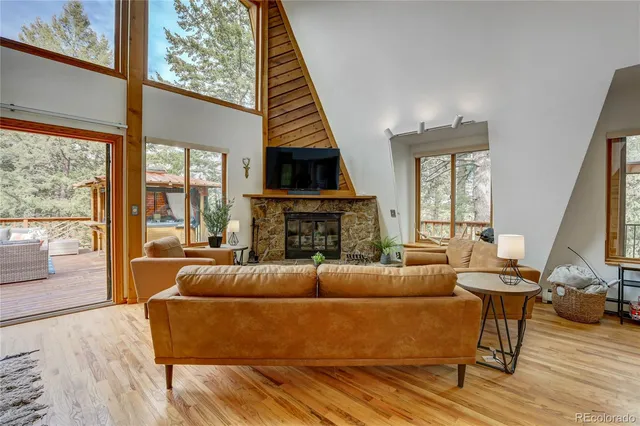 a living room with fireplace furniture and a large window