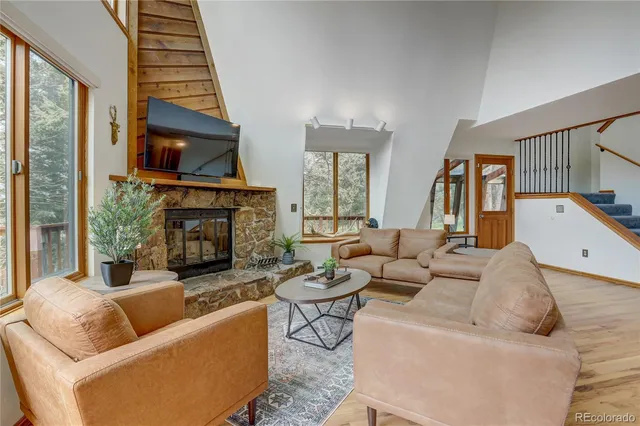 a living room with furniture a fireplace and a flat screen tv