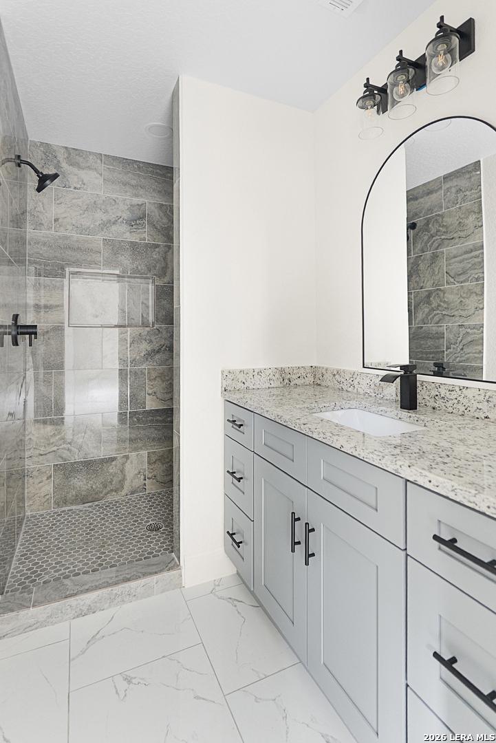845 Tee Drive Spring Branch, TX 78070 - Photo 17 of 18 a bathroom with a granite countertop sink a mirror and shower