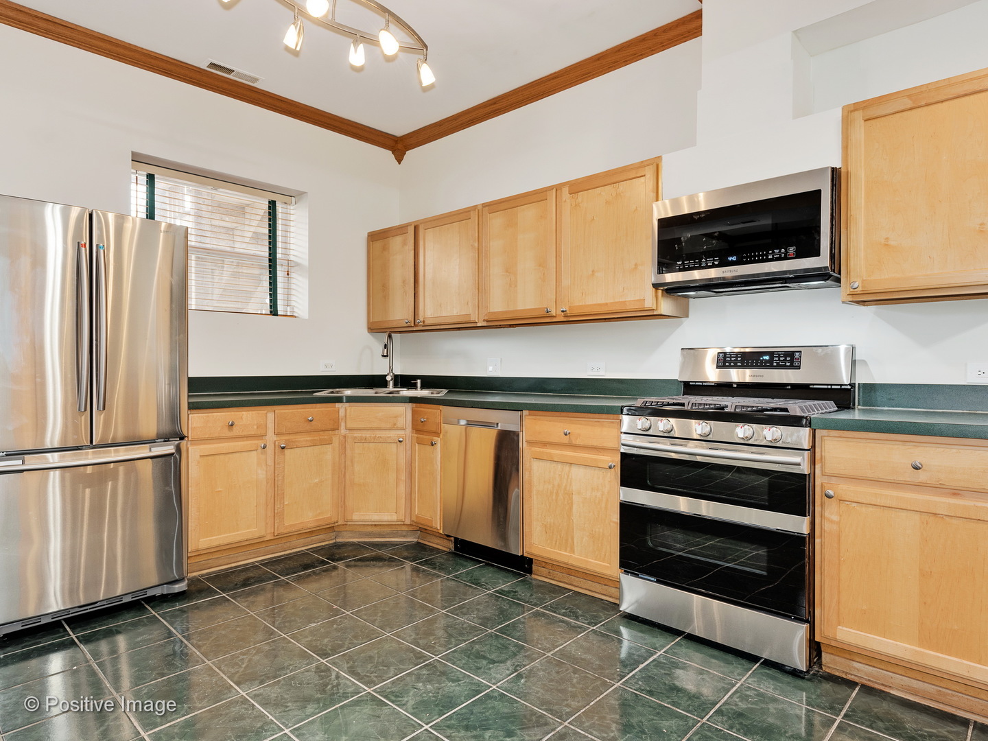 4417 North Racine Avenue, Unit 2N Chicago, IL 60640 - Photo 11 of 22 a kitchen with stainless steel appliances a stove a microwave and a refrigerator