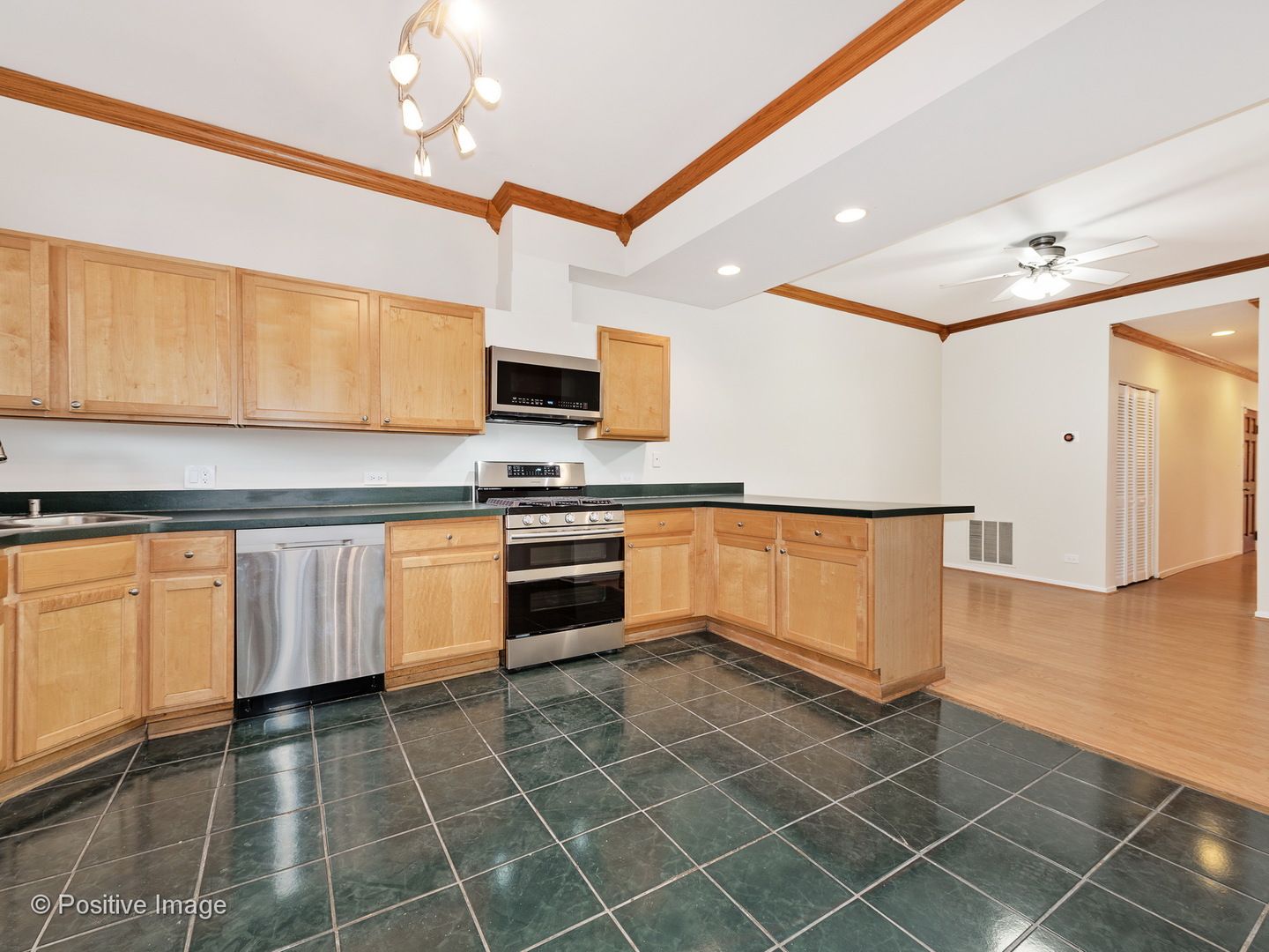 4417 North Racine Avenue, Unit 2N Chicago, IL 60640 - Photo 12 of 22 a kitchen with stainless steel appliances a stove a microwave and white cabinets