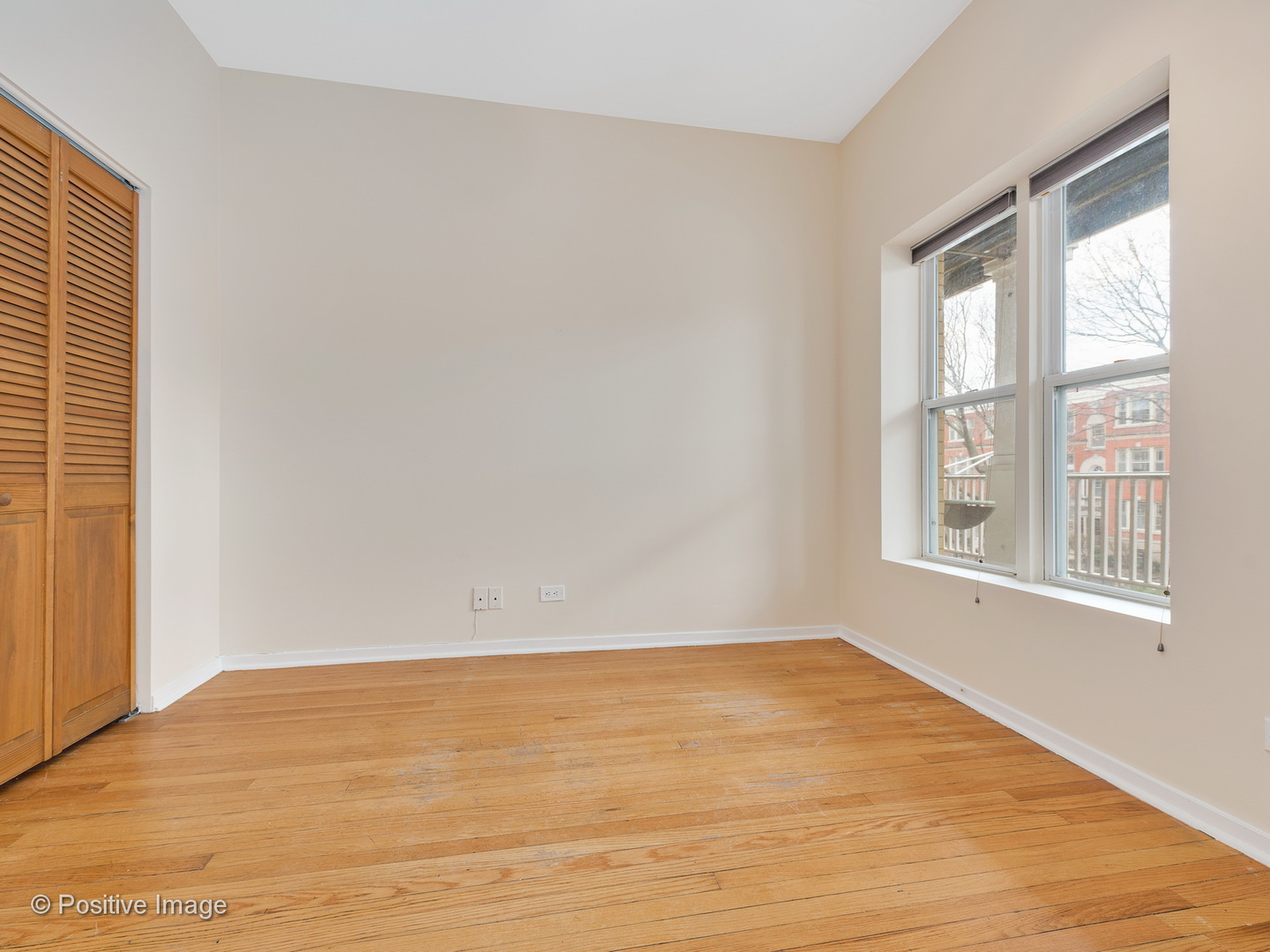 4417 North Racine Avenue, Unit 2N Chicago, IL 60640 - Photo 6 of 22 a view of an empty room with wooden floor and a window