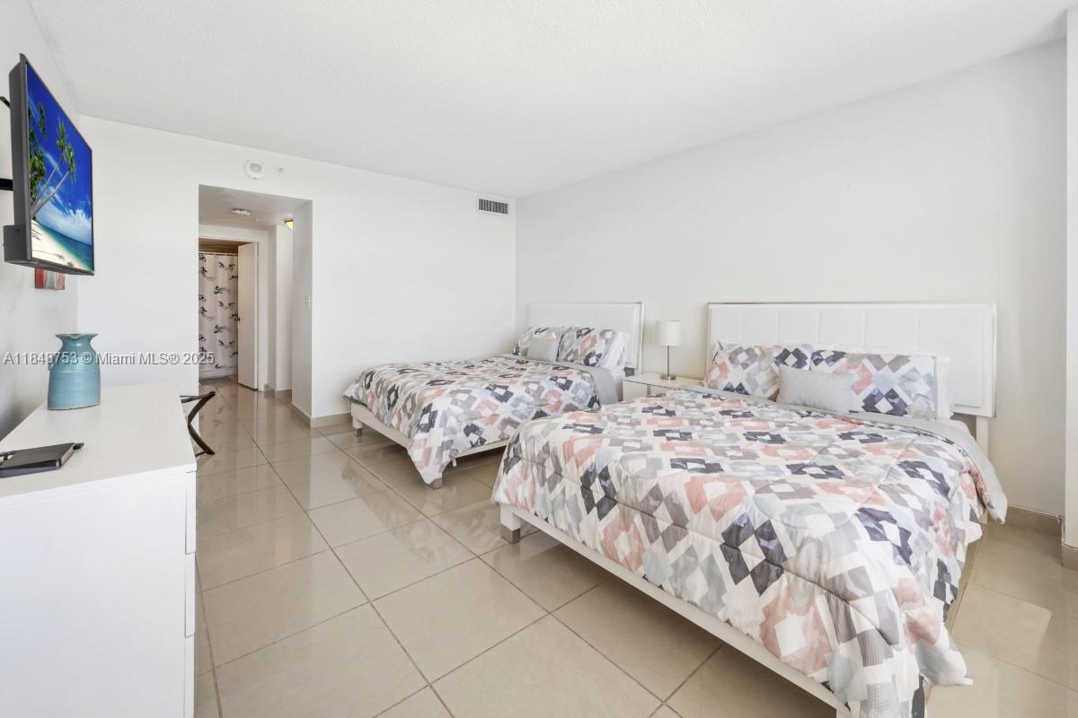 5601 Collins Avenue, Unit 511 Miami Beach, FL 33140 - Photo 8 of 34 a bedroom with two beds and painting on the wall