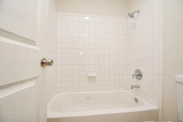 a white bath tub sitting next to a white sink and vanity