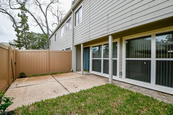 a backyard of a house with plants and wooden fence