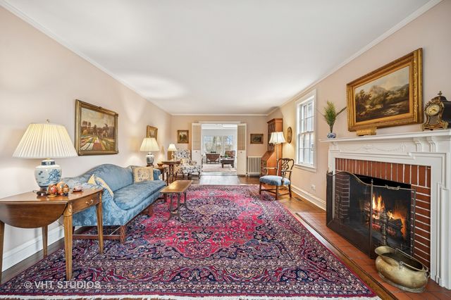 a living room with furniture a rug a fireplace and a window
