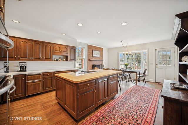 a kitchen with stainless steel appliances granite countertop a stove a sink dishwasher and a refrigerator with wooden floor