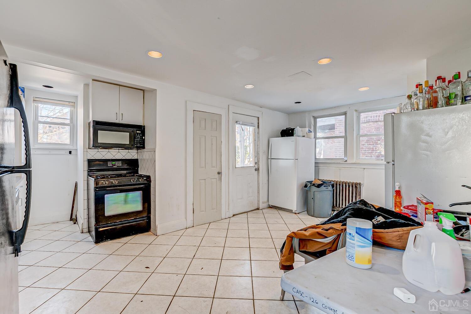 32 Prosper Street New Brunswick, NJ 08901 - Photo 22 of 30 a room with furniture a flat screen tv and a refrigerator