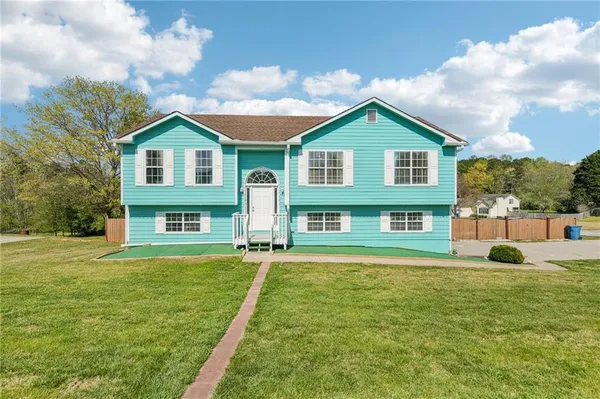 a front view of a house with a yard and trees