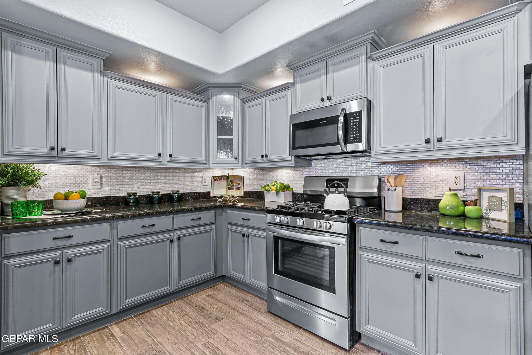 14045 Tower Point Way El Paso, TX 79938 - Photo 11 of 46 a kitchen with stainless steel appliances granite countertop grey cabinets a stove a sink and dishwasher