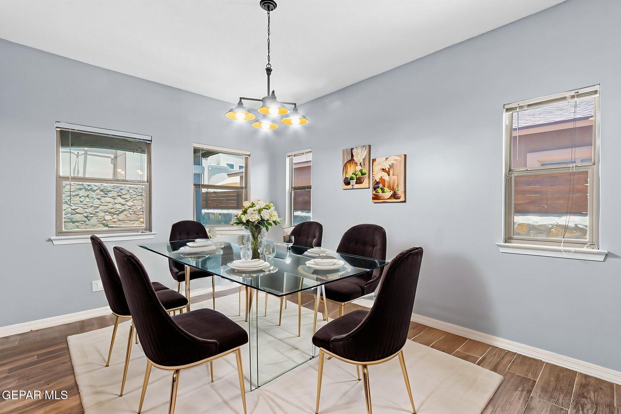 14045 Tower Point Way El Paso, TX 79938 - Photo 13 of 46 a view of a dining room with furniture a chandelier and wooden floor