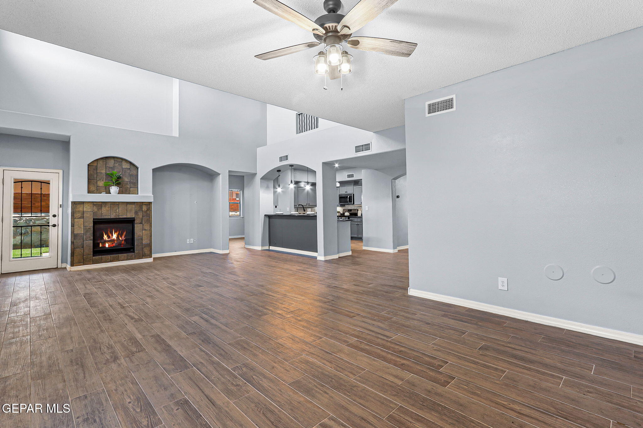 14045 Tower Point Way El Paso, TX 79938 - Photo 15 of 46 an empty room with wooden floor fireplace and a window