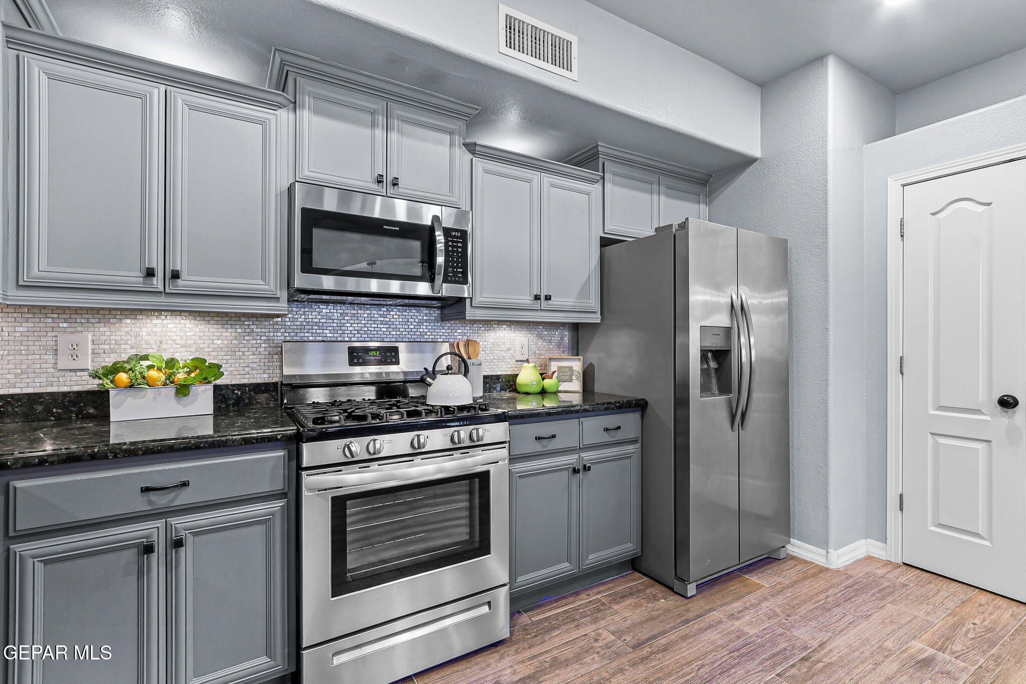 14045 Tower Point Way El Paso, TX 79938 - Photo 10 of 46 a kitchen with stainless steel appliances granite countertop a refrigerator stove a sink and dishwasher with wooden floor