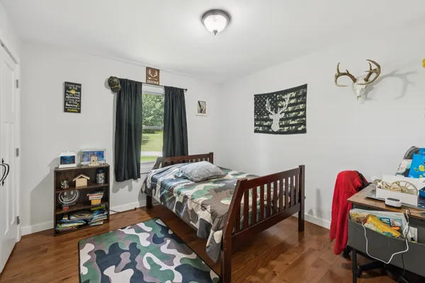 a bedroom with a bed and wooden floor