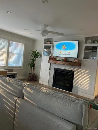 a living room with furniture a flat screen tv and a fireplace