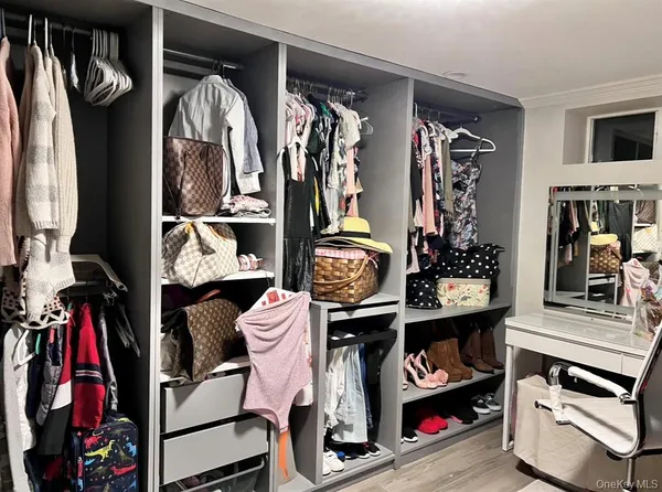 a view of walk in closet with clothes and shoes
