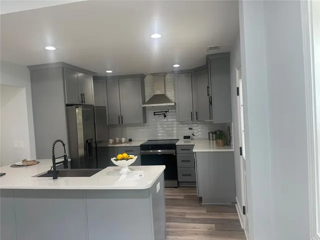 a kitchen with stainless steel appliances granite countertop a sink stove and refrigerator