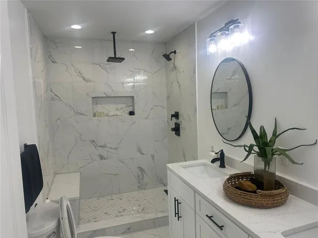 a bathroom with a sink a toilet and a mirror