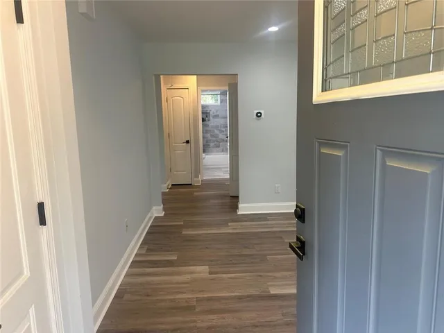 a view of a hallway with wooden floor and closet