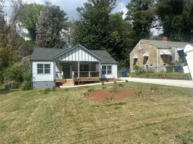 a view of a house with a yard and sitting area
