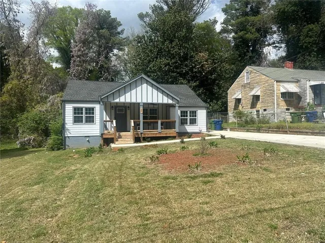 a view of a house with a yard and sitting area