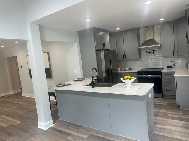 a kitchen with stainless steel appliances granite countertop a sink stove and refrigerator