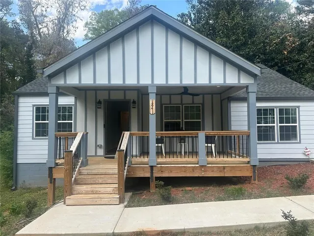 a porch with a bench next to a yard