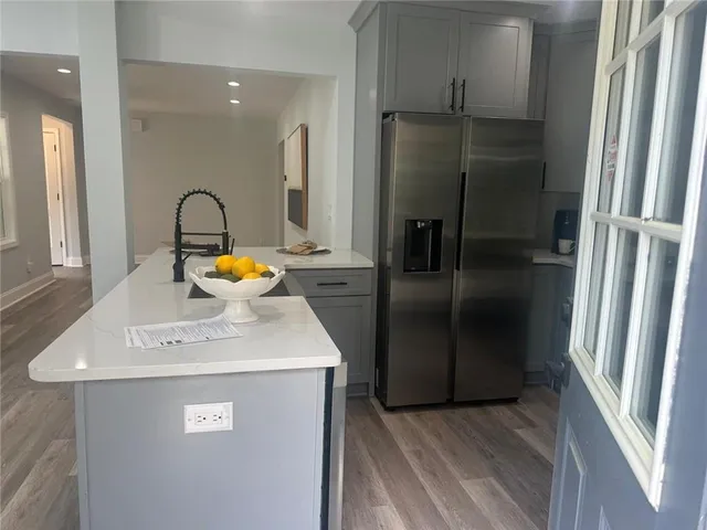 a kitchen with stainless steel appliances granite countertop a refrigerator and a sink