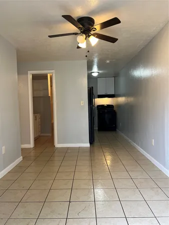 a view of an empty room with a chandelier fan