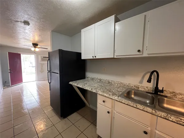 a kitchen with granite countertop a refrigerator and a sink