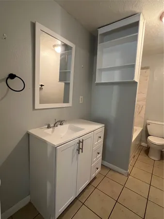 a bathroom with a sink toilet and mirror